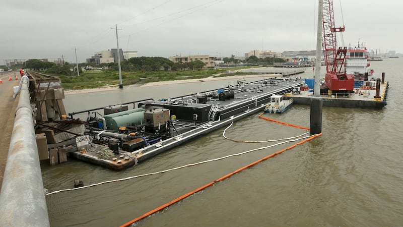 Spill booms surround a barge at the Pelican Island bridge in Galveston, Texas, Wednesday, May...