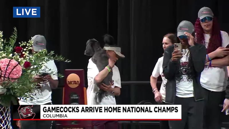 Dawn Staley with her dog Champ and their newest National Championship trophy.