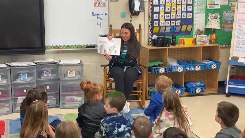 CCU student-athlete reading to Kindergartners in an elementary school classroom.