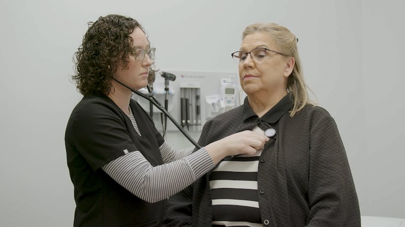 Physician assistant listening to a patient's heart.