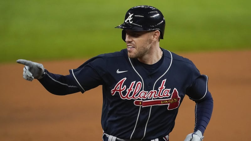 Atlanta Braves' Freddie Freeman points after a home run during the first inning in Game 1 of a...