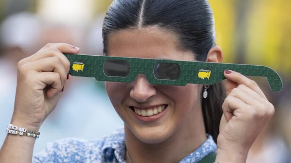 Patrons got eclipse glasses as they entered the gates at Augusta National Golf Club on April...