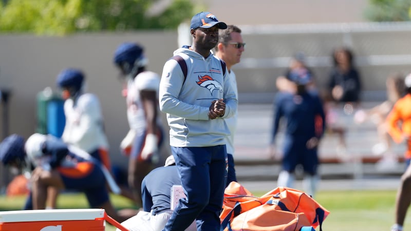 FILE - Denver Broncos defensive coordinator Ejiro Evero takes part in drills during an NFL...