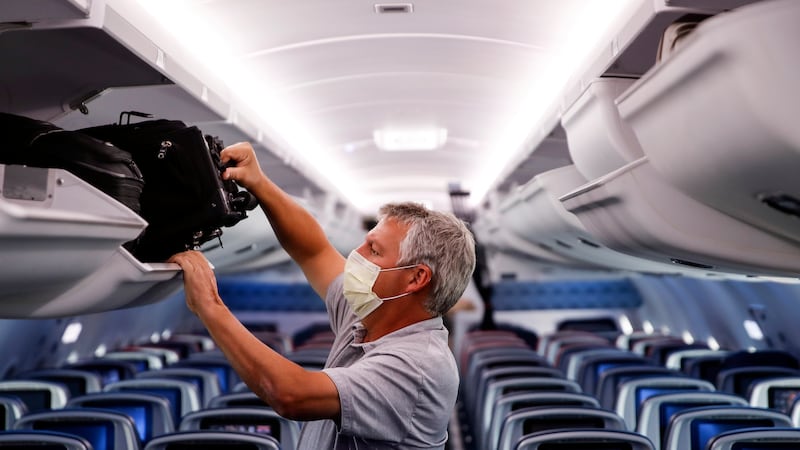FILE - In this May 28, 2020, file photo, a passenger wears personal protective equipment on a...