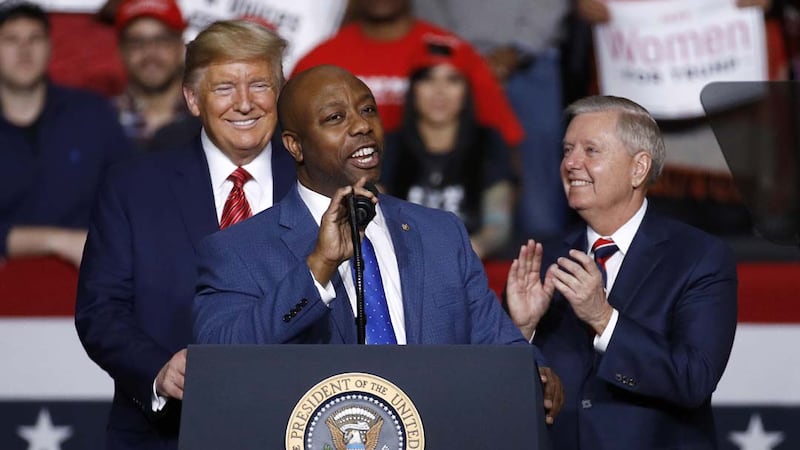 Sen. Tim Scott, R-S.C., speaks in front of President Donald Trump and Sen. Lindsey Graham,...
